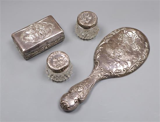 An Edwardian repousse silver Reynolds Angels soap box by William Comyns, a silver hand mirror and two mounted toilet jars.